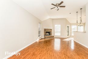 Midlothian house for rent - A spacious room with a fireplace and a ceiling fan.