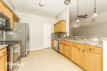 Midlothian house for rent - A kitchen with wooden cabinets and a marble countertop.