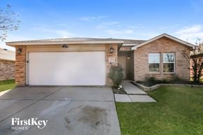 Denton house for rent - A house with a garage door and a sign that says "FirstKey Homes".