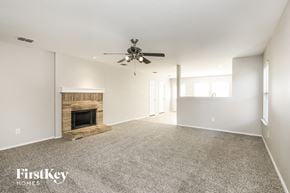 Denton house for rent - A spacious living room with a fireplace and a ceiling fan.