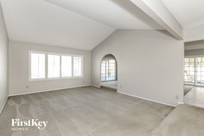 Glendale house for rent - A spacious room with a large window and a doorway leading to another room.