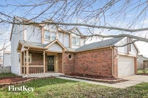 Indianapolis house for rent - A house with a brick facade and a white garage door is for sale.