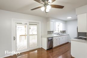 Kansas City house for rent - a kitchen with white cabinets and a sliding glass door to a deck