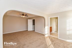 Douglasville house for rent - an empty living room with a ceiling fan and a door to a hallway