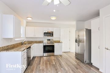 O'fallon house for rent - A kitchen with white cabinets and a wooden floor.