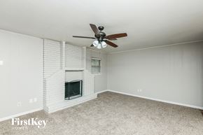 Fort Worth house for rent - A room with a fireplace and a ceiling fan.