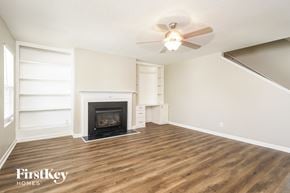 Kernersville house for rent - A living room with a fireplace and a ceiling fan.