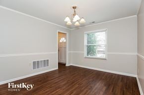 Charlotte house for rent - the living room of an empty house with wood flooring and a window