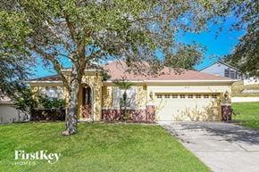 Clermont house for rent - a house with a garage and a tree in front of it