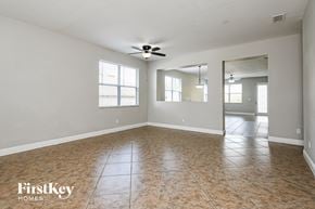 Clermont house for rent - an empty living room with a ceiling fan and a window