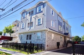 Elizabeth apartment for rent - a grey and blue apartment building with a black fence