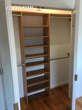Brooklyn apartment for rent - A tall wooden shelf unit with many shelves is in a room.