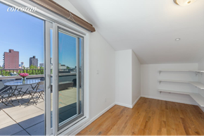 Brooklyn apartment for rent - A room with a sliding glass door leading to a balcony with a table and chairs.