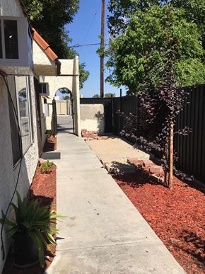 Northridge apartment for rent - A white house with a red roof and a concrete walkway.