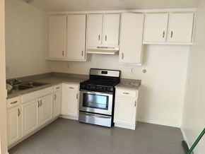 Northridge apartment for rent - A kitchen with white cabinets and a black stove top oven.