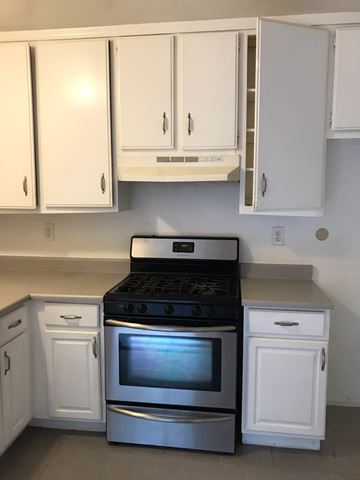 Northridge apartment for rent - A white kitchen with a black stove top oven.