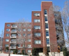 Toronto apartment for rent - a red brick apartment building with trees in front of it