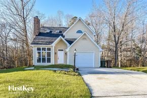 Greensboro house for rent - a white house with a white garage door and a driveway
