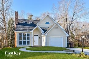 Greensboro house for rent - a white house with a white garage door and a lawn