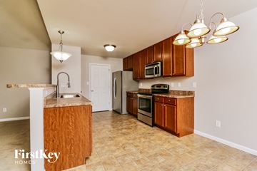 O'fallon house for rent - a kitchen with wooden cabinets and stainless steel appliances