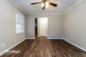Snellville house for rent - an empty living room with a ceiling fan and wood flooring