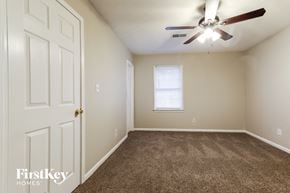 Snellville house for rent - a bedroom with carpeted flooring and a ceiling fan
