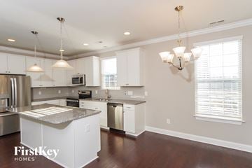 Kernersville house for rent - a kitchen with white cabinets and a counter top