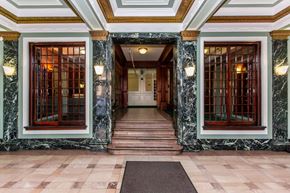 San Francisco apartment for rent - A hallway with marble floors and walls, and wooden doors.