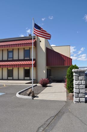 Yakima apartment for rent - A building with a red awning and an American flag on top.