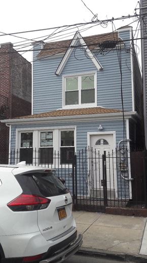 Brooklyn apartment for rent - a blue house with a white car parked in front of it