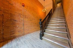 Toronto apartment for rent - the staircase leading up to the second floor of a building with brick walls and wood