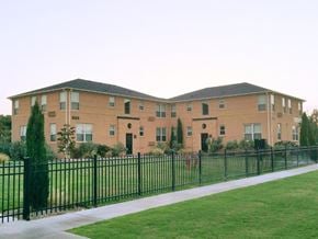 Odessa apartment for rent - a large brick apartment building behind a black fence
