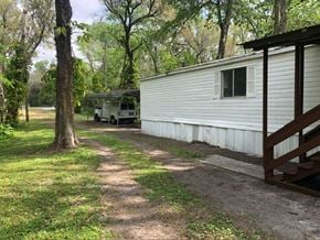Thonotosassa house for rent - a trailer parked next to a house in the woods