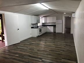 Thonotosassa house for rent - an empty kitchen with a wooden floor and white cabinets