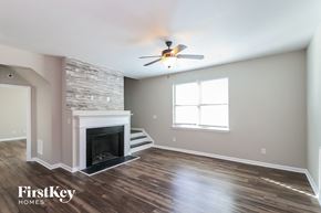 Cumming house for rent - a living room with a fireplace and a ceiling fan