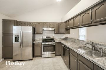 Fishers house for rent - a kitchen with stainless steel appliances and marble counter tops