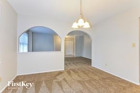 Ballwin house for rent - a living room with an arched opening to a dining room
