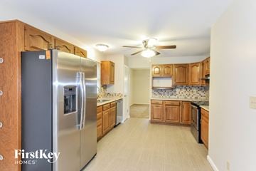 Ballwin house for rent - a kitchen with wooden cabinets and a stainless steel refrigerator