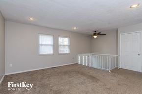 Mason house for rent - A spacious room with a fan and a white door.