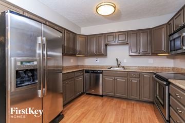 Mason house for rent - A kitchen with wooden cabinets and a stainless steel refrigerator.