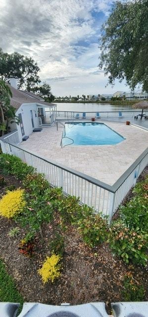 St. Petersburg apartment for rent - A pool surrounded by a fence and some bushes.