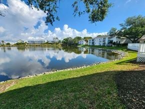 St. Petersburg apartment for rent - A serene lake surrounded by houses and trees under a partly cloudy sky.