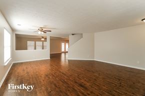 Dallas house for rent - an empty living room with wood floors and a ceiling fan