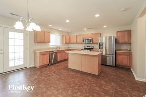 Dallas house for rent - a kitchen with wooden cabinets and stainless steel appliances