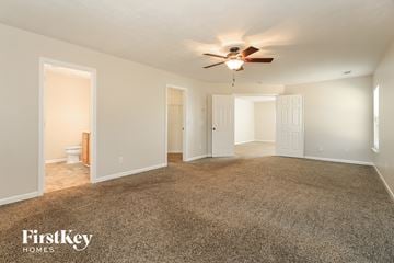 Dallas house for rent - a spacious living room with carpet and a ceiling fan