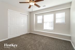 Dallas house for rent - the master bedroom has a large window and a ceiling fan