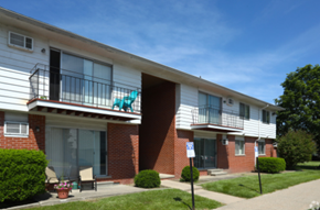 Trenton apartment for rent - an apartment building with two balconies and a porch with a rocking chair
