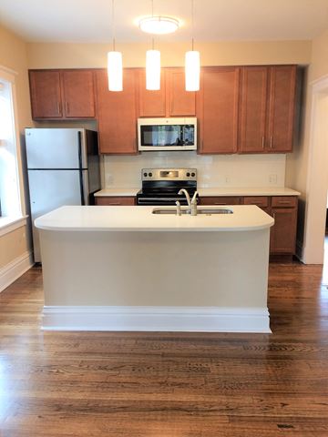 St. Louis apartment for rent - a kitchen with a white island and wooden cabinets