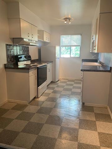 Albuquerque apartment for rent - A kitchen with white appliances and a checkered floor.