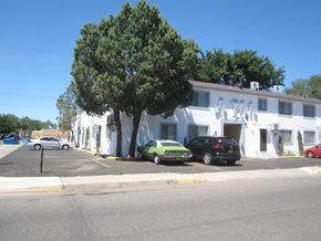 Albuquerque apartment for rent - A white building with a tree in front of it.